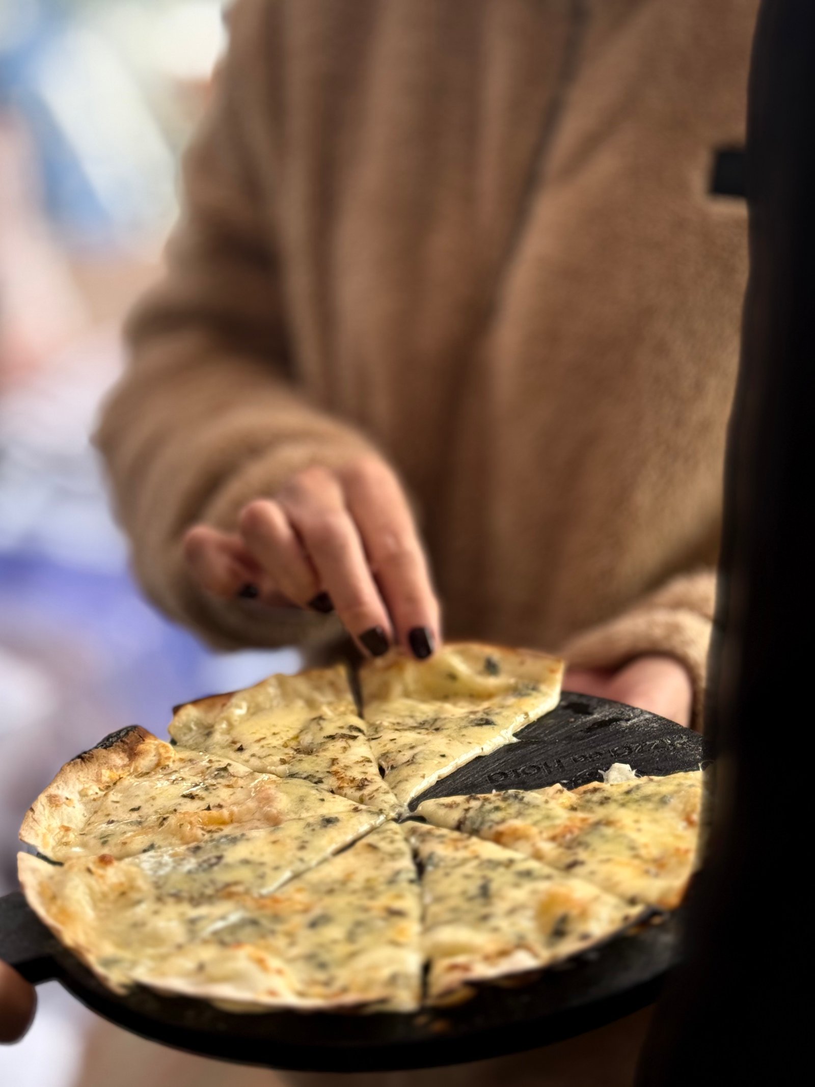 Pessoa servindo pizza da Pizza Da Hora em evento